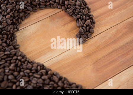 Kaffee Bohnen bilden Form auf Holztisch Stockfoto