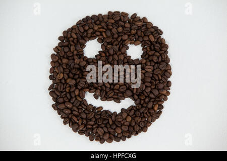 Kaffee Bohnen bilden Smiley-Gesicht auf weißem Hintergrund Stockfoto