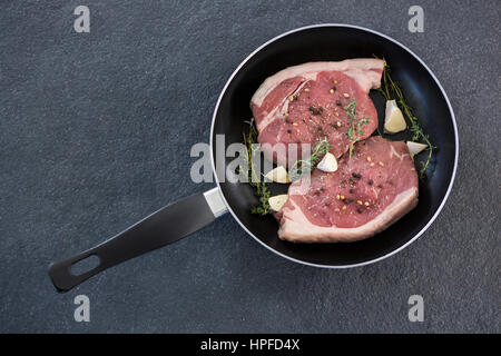 Lende hacken und Kräutern in Pfanne auf schwarzem Hintergrund Stockfoto