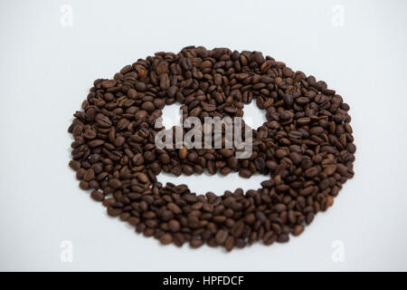 Kaffee Bohnen bilden Smiley-Gesicht auf weißem Hintergrund Stockfoto