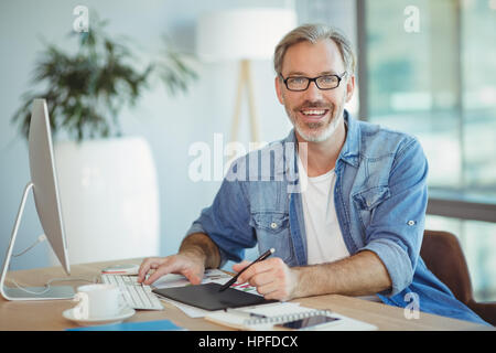 Porträt von männlichen Grafik-Designer mit Grafiktablett in office Stockfoto