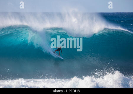 Ein Surfen auf einer Welle an Rohrleitung auf der Nordküste von Oahu. Stockfoto