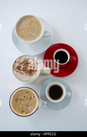 Draufsicht auf verschiedene Arten von Kaffee in Tassen auf weißem Hintergrund angeordnet Stockfoto