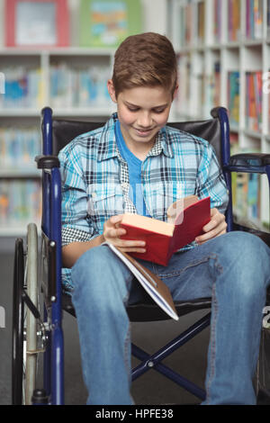 Behinderte Schüler Lesebuch in Bibliothek in der Schule Stockfoto