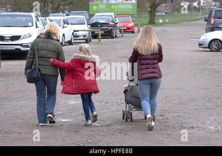 Grand Mutter mit Tochter und Enkel zu Fuß in Richtung Auto auf Parkplatz in der Nähe von Monkey Forest, Trentham, Staffordshire, Vereinigtes Königreich, Winter 2017. Stockfoto