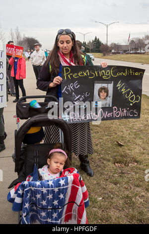 Troy, Michigan, USA. 21. Februar 2017. Wähler Streikposten das Büro des republikanischen Kongressabgeordneten Dave Trott, verlangen, dass er eine Bürgerversammlung zu halten, so dass sie ihren Widerstand gegen die geplante Aufhebung der Obamacare bekannt machen könnte. Sie sagten, dass der Vertreter ein "Huhn" für Reisen nach Indien während des Februar Congressional Aussparung anstatt Treffen mit den Wählern in seinem Bezirk war. Eine Frau brachte ihre zwei kleinen Kinder, von denen Diabetiker ist. Bildnachweis: Jim West/Alamy Live-Nachrichten Stockfoto