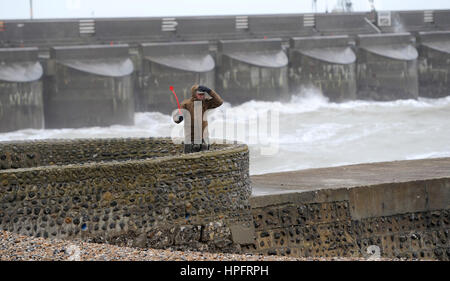 Brighton, UK. 22. Februar 2017. Eine Walker hängt an seinen Hut bei starkem Wind auf Brighton Seafront Vormittag als Sturm Doris Köpfe in Richtung Großbritannien in den nächsten Tagen. Bildnachweis: Simon Dack/Alamy Live-Nachrichten Stockfoto