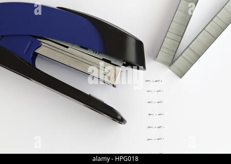 Blauen Tacker mit Klammern und Papier auf weißem Tisch Stockfoto