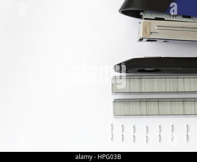 Blauen Hefter und Heftklammern mit Papier auf Holz Tisch Stockfoto