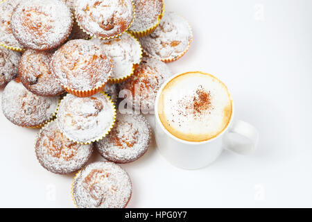 Leckere Muffins und eine Tasse heißen Kaffee auf weiß Stockfoto