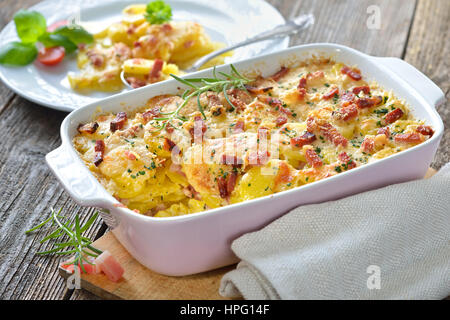 Frisch aus dem Ofen serviert herzhafte Kartoffel-Gratin mit Parmesan-Käse, Sahne und köstlichen Speck aus Südtirol Stockfoto