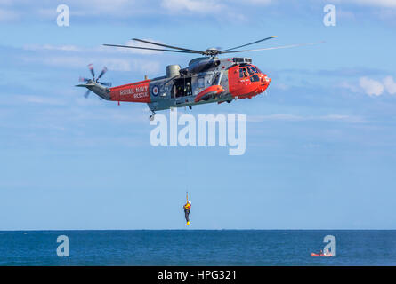 DAWLISH, Großbritannien - 23. August 2014: Royal Navy Sea King Search and Rescue Helikopter demonstrierende Winde Rettung auf der Dawlish Airshow Stockfoto