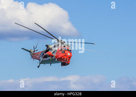 DAWLISH, Großbritannien - 23. August 2014: Royal Navy Sea King Such- und Rettungshubschrauber fliegen auf der Dawlish Airshow Stockfoto