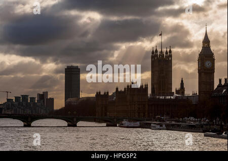 Mit Blick auf den Houses of Parliament von Hingerford Brücke Steg mit Sonnenstrahlen die Wolken piercing. Stockfoto