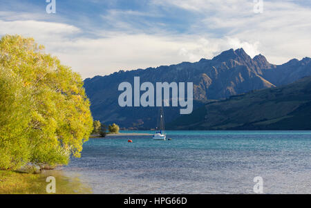 Glenorchy, Otago, Neuseeland. Blick über Lake Wakatipu zum Zahn-Gipfel, Abend, einsame Yacht vor der Küste verankert. Stockfoto