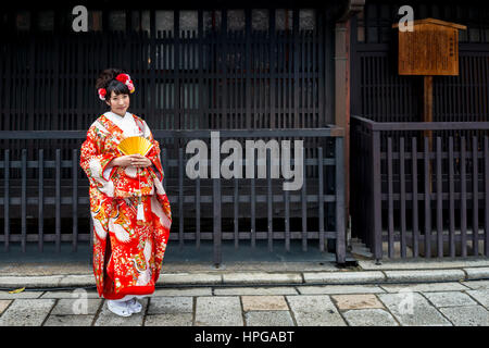 Junge japanische Braut im Kimono stehen außerhalb eines alten Gebäudes, Gion Bezirk, Kyoto, Japan Stockfoto
