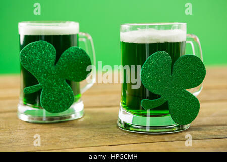 St. Patricks Day 2 Tassen grüne Bier mit Shamrock auf der Holzoberfläche Stockfoto