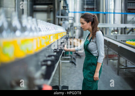 Weibliche Fabrikarbeiter Inspektion Produktionslinie im Getränke-Produktionsstätte Stockfoto