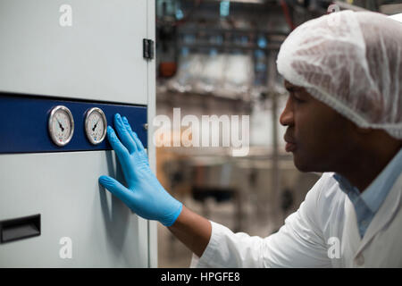 Fabrik-Ingenieur Überwachung eine Manometer in Getränke-Produktionsanlage Stockfoto