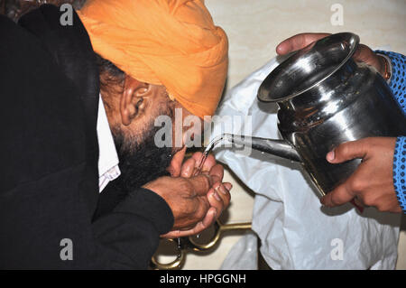 Pilger trinken Weihwasser, Bangla Sahib Gurudwara, Sikh Tempel, Delhi, Indien Asien (Photo Copyright © Saji Maramon) Stockfoto