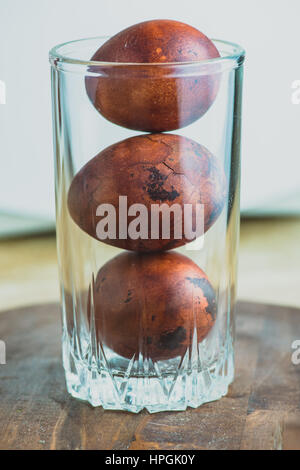 Ostereier aus Glas auf hölzernen Hintergrund. Malte Braun mit Flecken und Risse. Nahaufnahme Makroaufnahme Top. Stockfoto