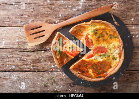 Geschnittenen Torte mit Sahne, Käse, Tomaten und Kräuter Closeup auf dem Tisch. Horizontale Ansicht von oben Stockfoto