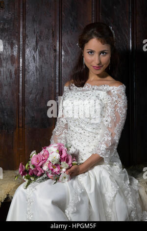 Georgeous Brünette Braut posiert im Innenbereich in ihr Hochzeitskleid Stockfoto