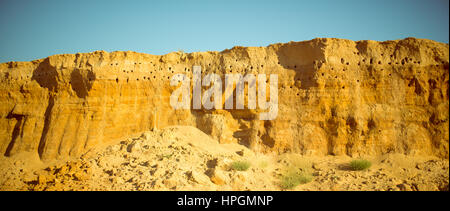 Klippe der gelb orange braun Sand Boden Ton unter den sonnigen Tag mit tiefblauen Himmel Stockfoto