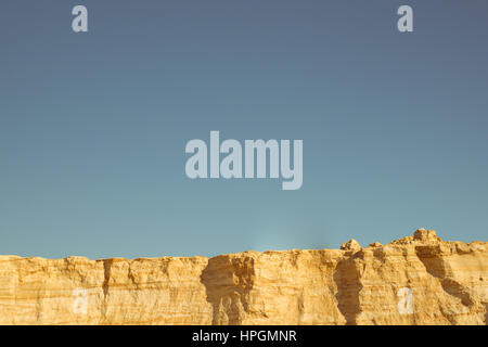 Klippe der gelb orange braun Sand Boden Ton unter den sonnigen Tag mit tiefblauen Himmel Stockfoto
