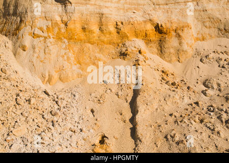 Klippe der gelb orange braun Sand Boden Ton unter den hellen, sonnigen Tag. Textur-Hintergrund Stockfoto