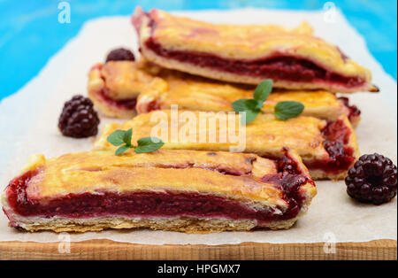 Scheiben von süßen Beeren Torte auf blauem Grund. Stockfoto