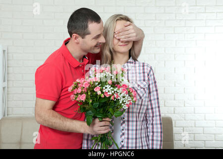 Valentinstag, Jubiläum, Event-Konzept - junge Frau erhält ein Geschenk von Blumenstrauß von ihrem Freund Stockfoto