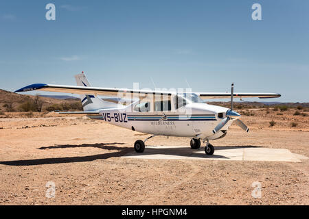 Eine Cessna 210, Registrierung V5-BUZ, sitzen auf dem Flugplatz bei Doro Nawas im westlichen Norden Namibias.  Es ist in den Farben der Wildnis Luft gemalt. Stockfoto