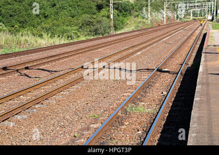 Zwei Gleise Vorsprung durch ländlichen Bahnhof bei Nshongweni in der Nähe von Durban, Südafrika Stockfoto