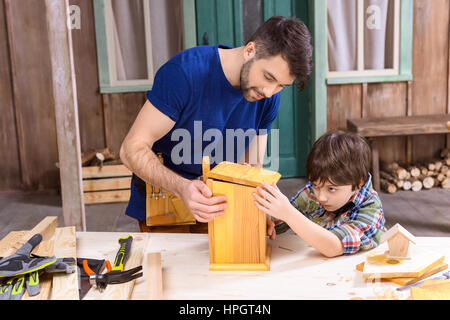 Vater und Sohn gemeinsam machen Holz Vogelhaus Stockfoto