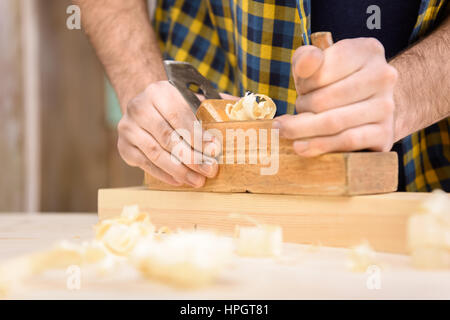 Schreiner Hobeln Holzbrett mit Hand-Flugzeug Stockfoto