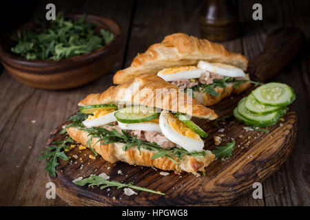 Thunfisch-Croissant-Sandwiches auf Holzbrett. Frische leckere Thunfisch-Salat-Sandwiches. Stockfoto
