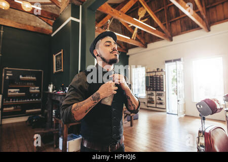 Schuss von professionellen männlichen Friseur Anpassung seine Krawatte im Friseursalon. Hipster Barbier in seinem Laden stehen. Stockfoto