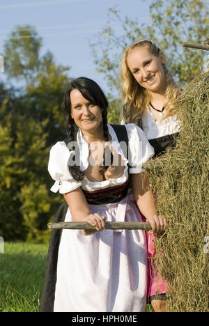 Modell veröffentlicht, Zwei Junge Frauen Im Dirndl Bei der Heuarbeit - Frauen im Dirndl Heu-Ernte Stockfoto