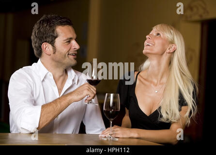 Modell veröffentlicht, Mann Und Frau einer Mit Wein eine der Bar - paar trinkt Wein an der bar Stockfoto