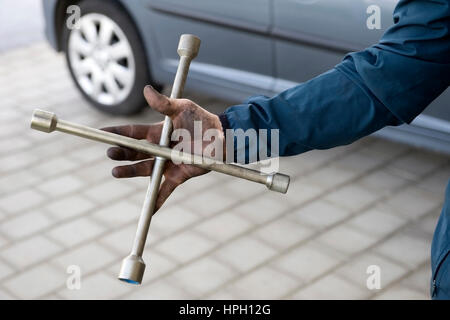 Model Release, Mechaniker Mit Kreuzschluessel in der Hand - Mechaniker mit Wheelbrace in der hand Stockfoto