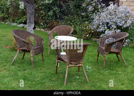 Rattanstühle und weißen Tisch in einem Garten. Raucherbereich Stockfoto