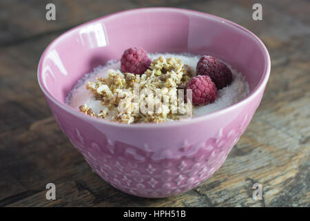 Gesundes Frühstück mit Kokos-Müsli und Himbeeren Stockfoto