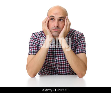 Denken legerer Mann sitzt und schaut sich isoliert auf weißem Hintergrund. Stockfoto