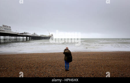 Eine Frau sieht das Meer am Strand in Brighton, East Sussex, unruhige Wetter vor dem vorausgesagten Sturm Doris Morgen beginnt. Stockfoto