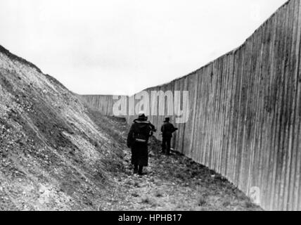 Das Bild der Nazi-Propaganda zeigt deutsche Wehrmachtssoldaten in einem Panzerabwehrgraben auf einem Stützpunkt an der Atlantischen Mauer. Veröffentlicht im Februar 1944. Ein Nazi-Reporter hat auf der Rückseite des Bildes geschrieben: "Stahl, Beton und Eisen - dies ist die Atlantische Mauer. Tag und Nacht durchstreifen kleine Gruppen ihren zugewiesenen Landstreifen in dem großen Panzerabwehrgraben. (3 Bilder.)“ Fotoarchiv für Zeitgeschichte / Archve - KEIN KABELDIENST - | weltweite Nutzung Stockfoto