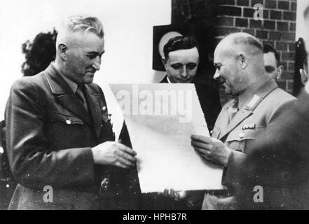 Die NS-Propaganda-Bild zeigt der Chef der zivile Angelegenheiten in Luxemburg, Gustav Simon (l.), Übergabe eines Zertifikats für herausragende Beiträge zu einem großen eine Luxemburger Firma. Aufgenommen im April 1942. Die Nazi-Propaganda auf der Rückseite des Bildes lautet "großen luxemburgischen Firma erhält die regionale Zertifikat für herausragende Beiträge. Das Luxemburger Unternehmen nahmen an der Performance-Wettbewerb zum ersten Mal 1941/42. Am 1. Mai konnten die Kreisleiter der Moselregion Gustav Simon Luxemburger Großkanzlei mit dem regionalen Zertifikat für präsentieren. Stockfoto