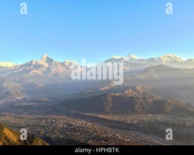 Annapurna Bergkette Ansicht nach Sonnenaufgang aus Sarangkot Sicht mit dem Dorf Pokhara in Nepal. Stockfoto
