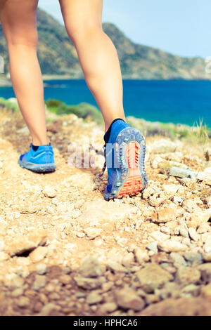 Wandern oder laufen Frau in schönen Bergen inspirierende Landschaft. Die Sohle der Sportschuh und Beine auf Rock Trail. Wanderer, trekking oder wandern von footp Stockfoto