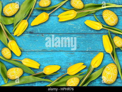 bunte hölzerne Ostern Hintergrund gelbe Tulpen Eiern auf rustikale alte Eiche Türkis hell blau Holzstruktur Stockfoto